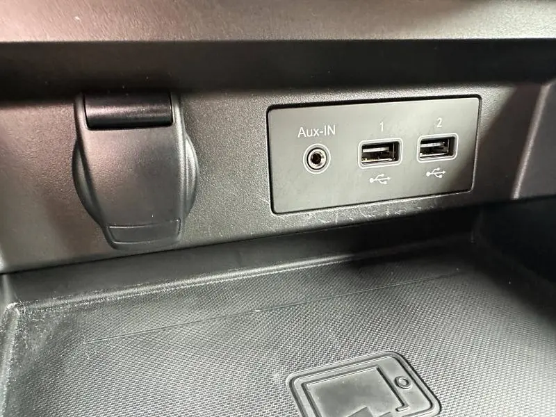 Gros plan sur la prise Aux-IN et deux ports USB intégrés dans la console centrale noire du Renault Arkana 2023.