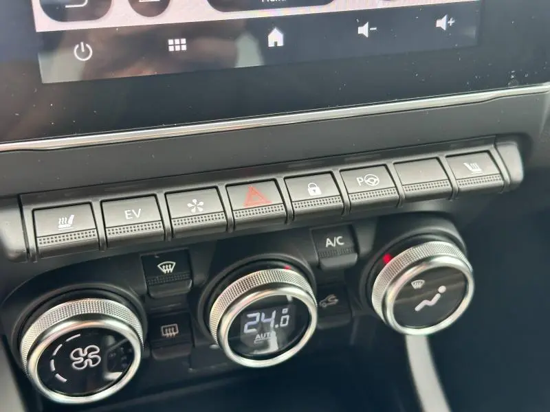 Détail de la console centrale avec commandes climatisation et boutons multifonctions du Renault Arkana noir métal 2023.