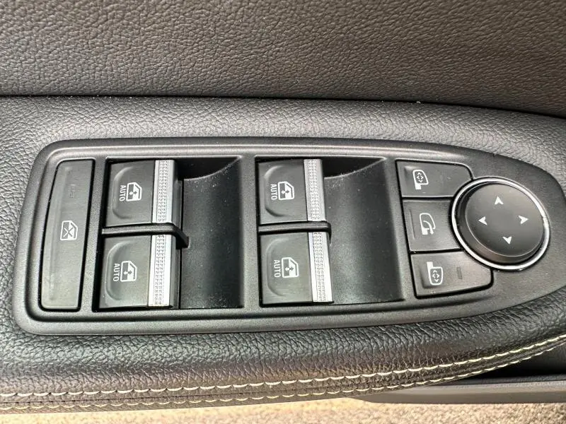 Gros plan sur les commandes de lève-vitres et rétroviseurs côté conducteur du Renault Arkana noir métal 2023.