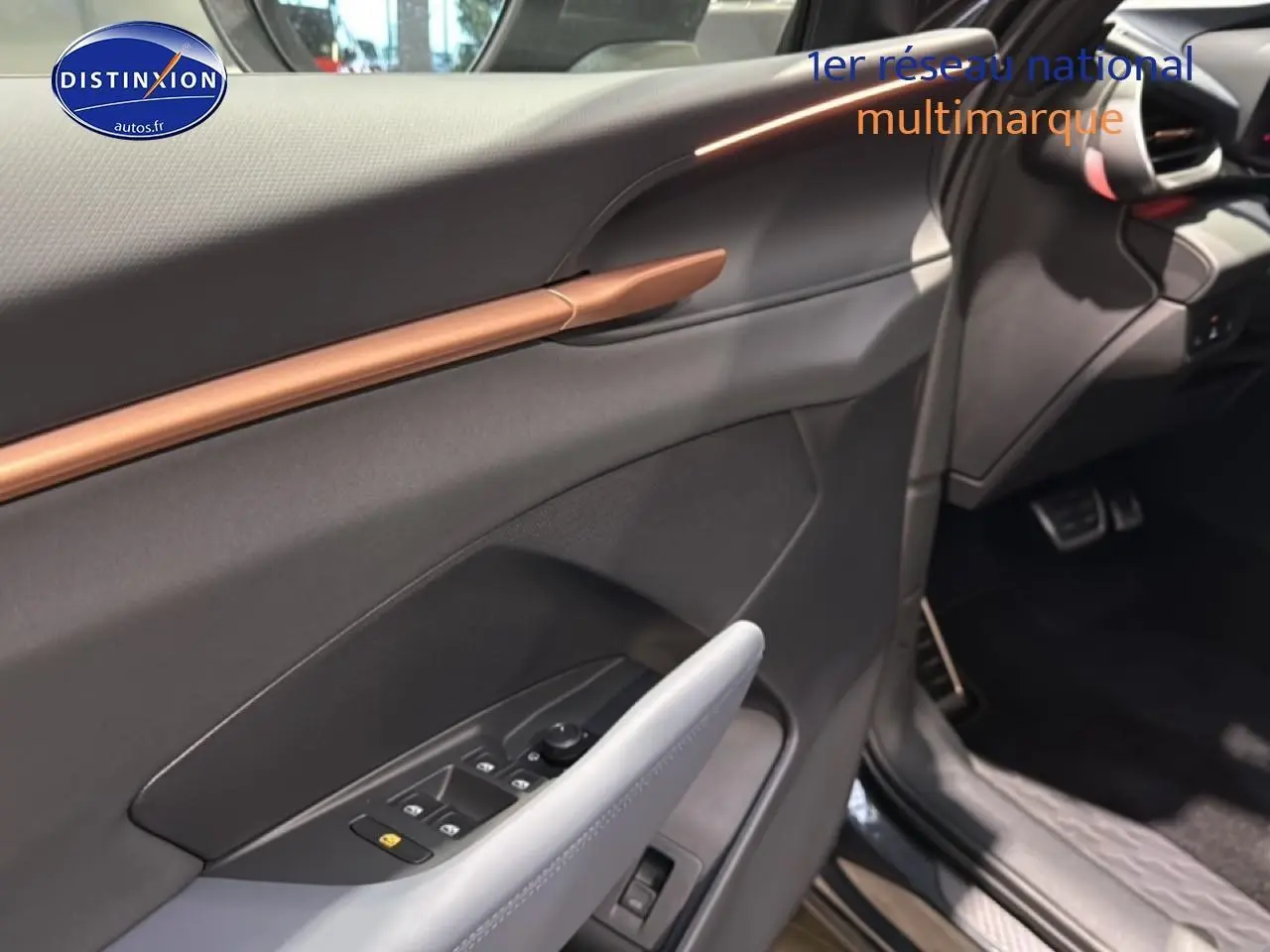 Vue intérieure côté conducteur de la CUPRA Terramar 2025 gris, avec garniture noire et insert cuivre sur la porte.