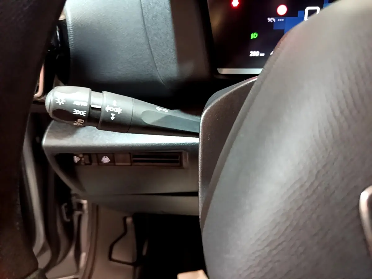 Gros plan sur la manette de commandes d’éclairage à gauche du volant gris foncé du Citroën C4 2021.