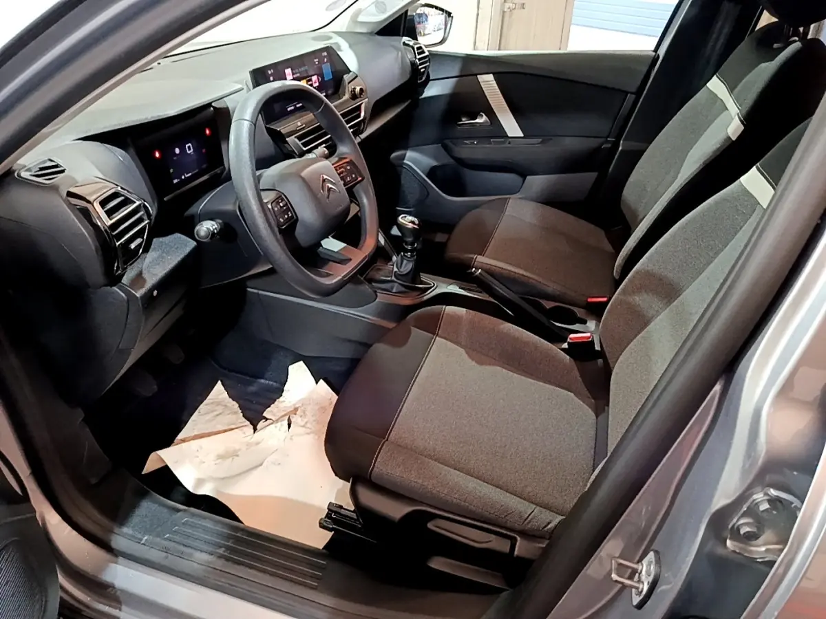 Intérieur avant droit de la Citroën C4 gris foncé 2021, volant multifonctions et tableau de bord avec écran tactile.