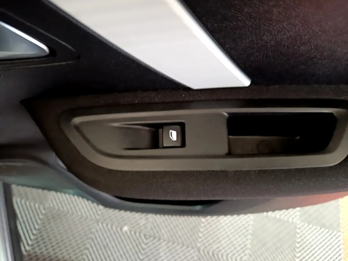 Détail de la poignée intérieure de porte arrière droite de la Citroën C4 gris foncé, bouton de verrouillage visible.