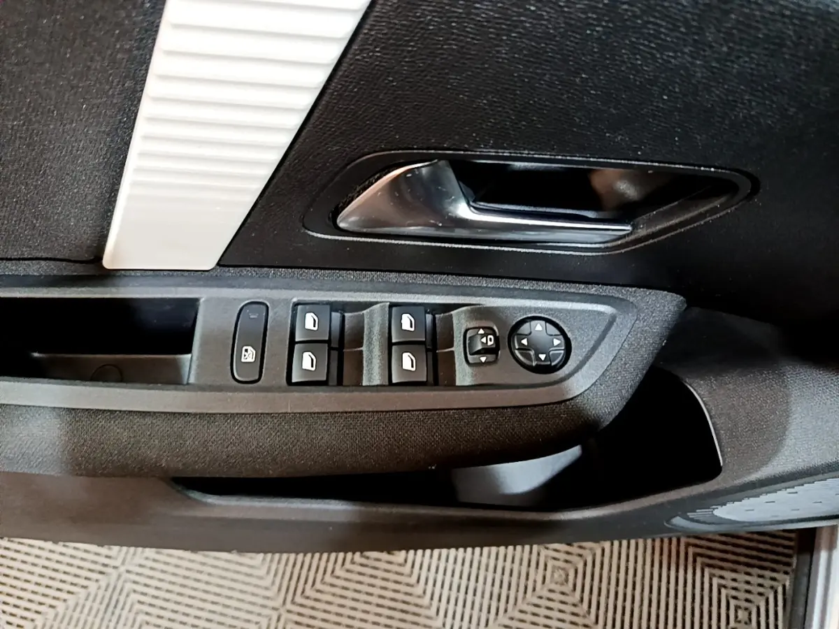 Vue rapprochée de la porte côté conducteur du Citroën C4 2021, montrant les commandes des vitres et rétroviseurs.
