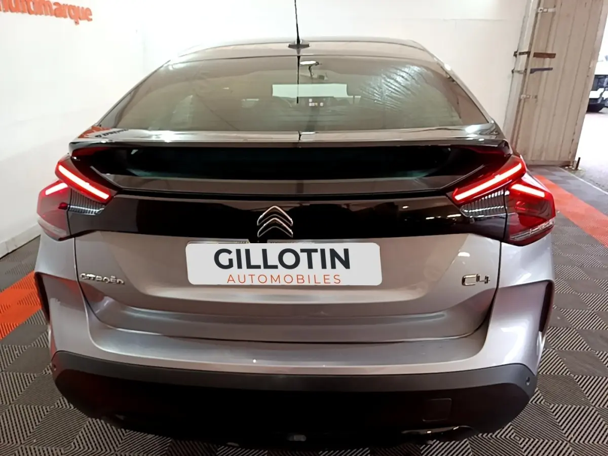 Vue arrière d'une Citroën C4 gris foncé avec feux LED en forme de boomerang et hayon noir brillant.