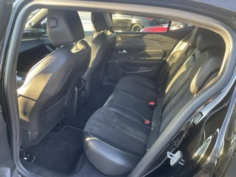 Vue intérieure arrière côté gauche du Peugeot 408 Hybrid 136 cv GT noir métal, mettant en valeur les sièges en cuir et alcantara.