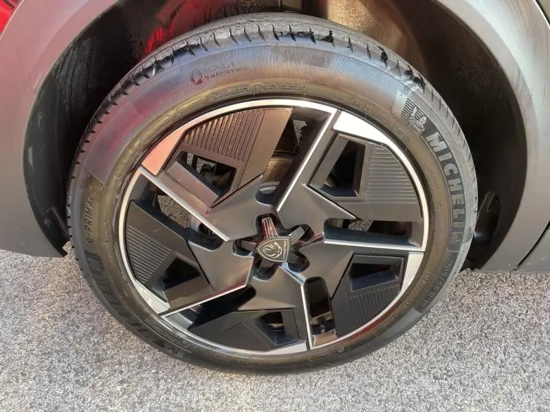 Gros plan sur la roue avant droite du Peugeot 408 Hybrid 136 cv GT noir métal, jante alliage au design moderne.