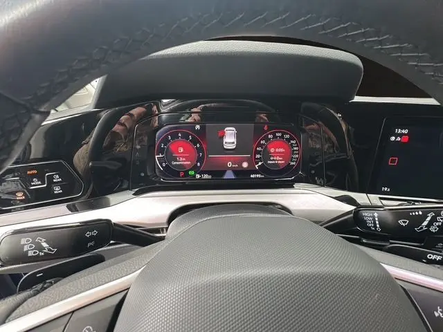 Vue depuis le poste de conduite du tableau de bord numérique de la Volkswagen Golf VIII bleu, affichant la caméra de recul active.