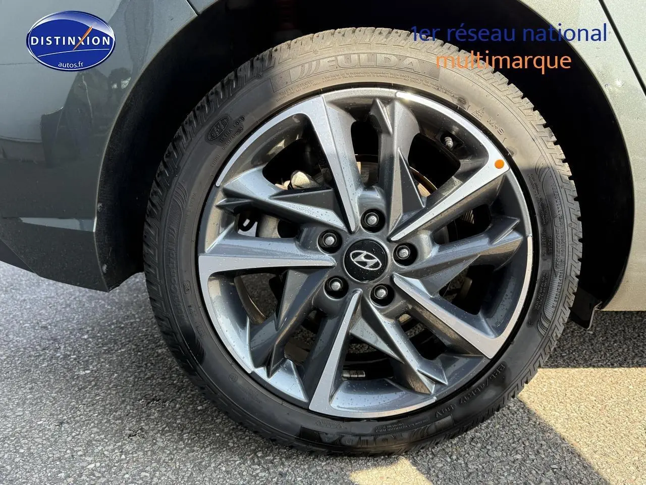 Gros plan sur la jante alu gris anthracite d'une Hyundai i30 2024 avec pneu hiver et logo Hyundai central.