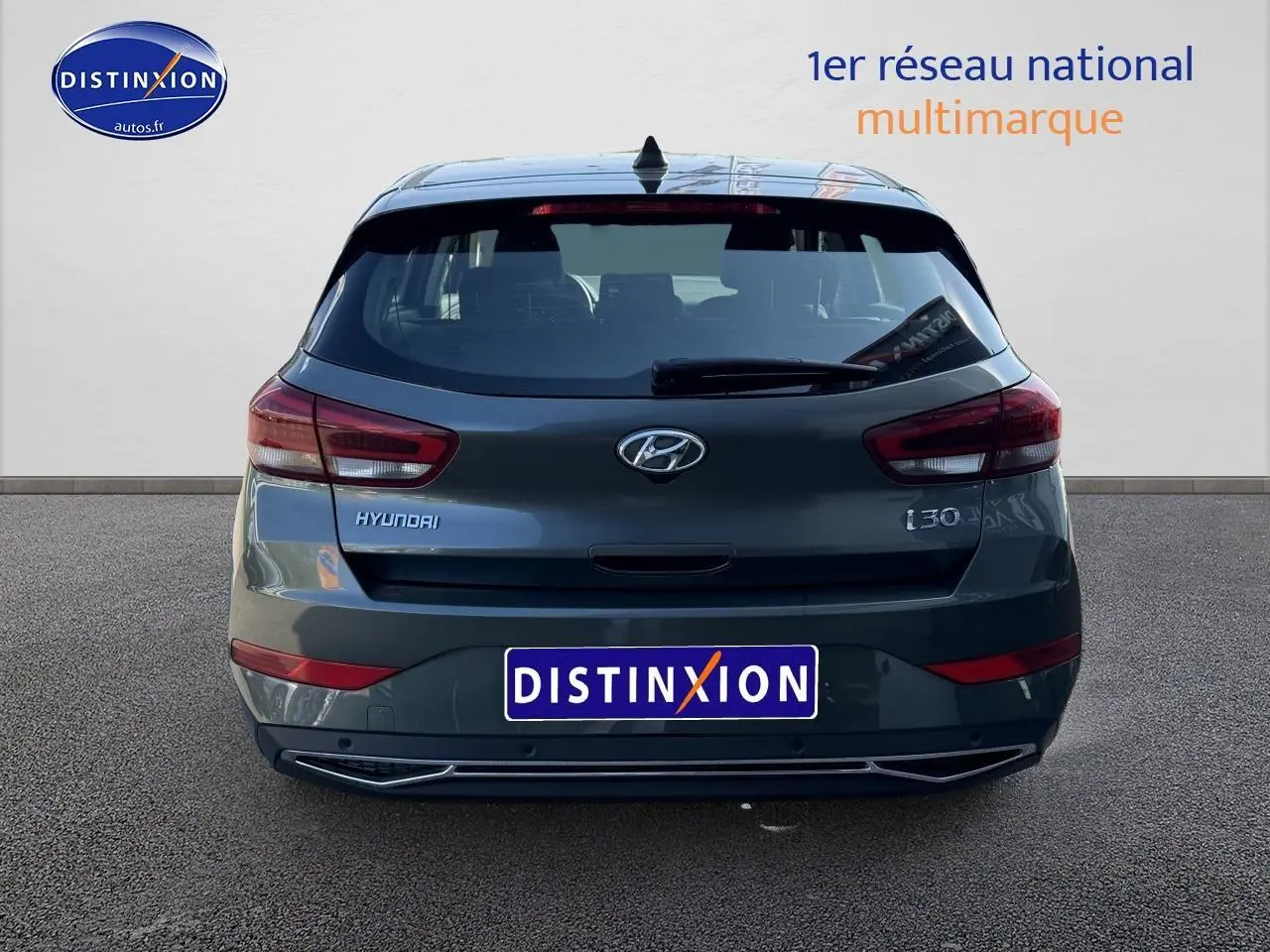 Vue arrière d'une Hyundai i30 gris anthracite 2024 avec feux LED et logo distinctif sur fond neutre.