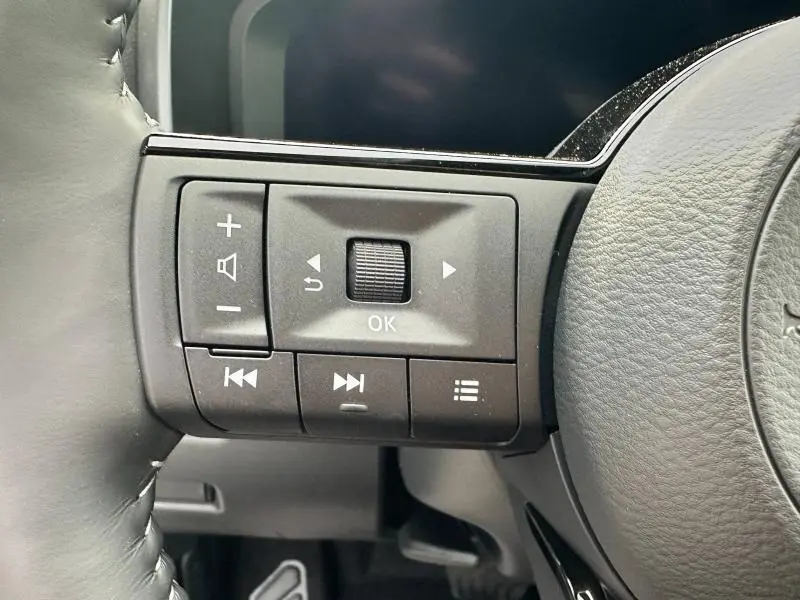 Gros plan sur les commandes multifonctions à gauche du volant gris du Nissan Qashqai e-POWER 190ch N-Design 2025.