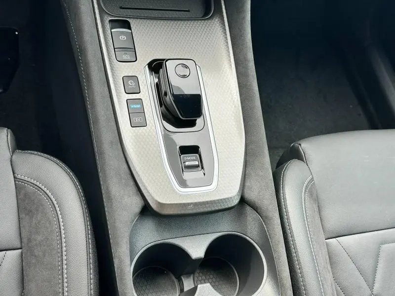 Gros plan sur la console centrale du Nissan Qashqai e-POWER 190ch N-Design 2025, avec levier de boîte auto et finition gris clair.