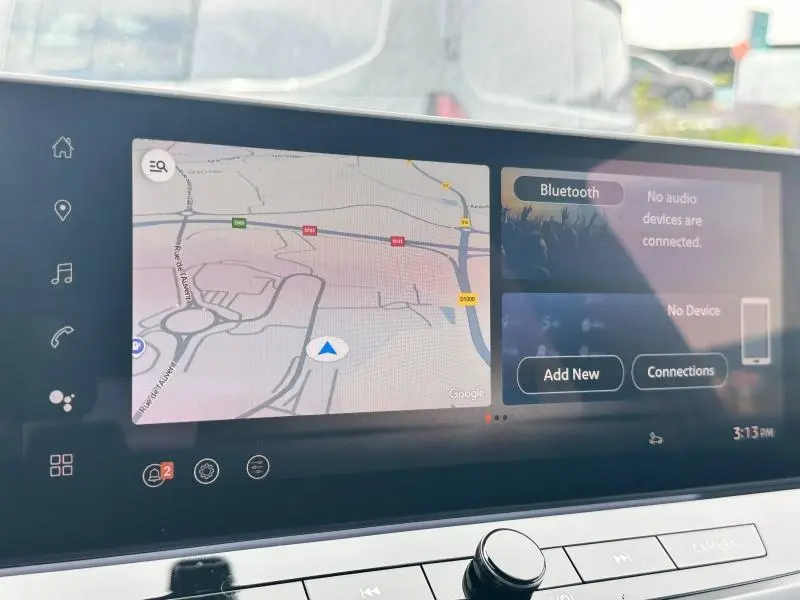 Tableau de bord du Nissan Qashqai e-POWER 2025 avec écran tactile affichant navigation et options Bluetooth.