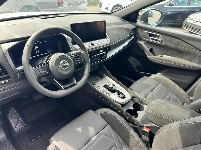 Intérieur du Nissan Qashqai e-POWER N-Design 2025 en vue côté conducteur, avec tableau de bord noir et écran tactile central.