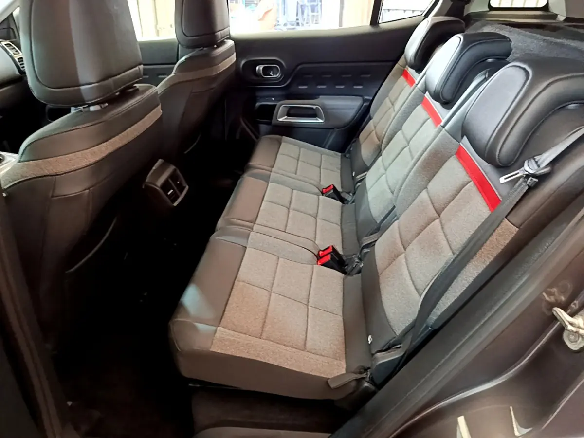 Vue latérale droite de l'intérieur arrière du Citroën C5 Aircross 2020, sièges gris tissu avec bande rouge et cuir noir.