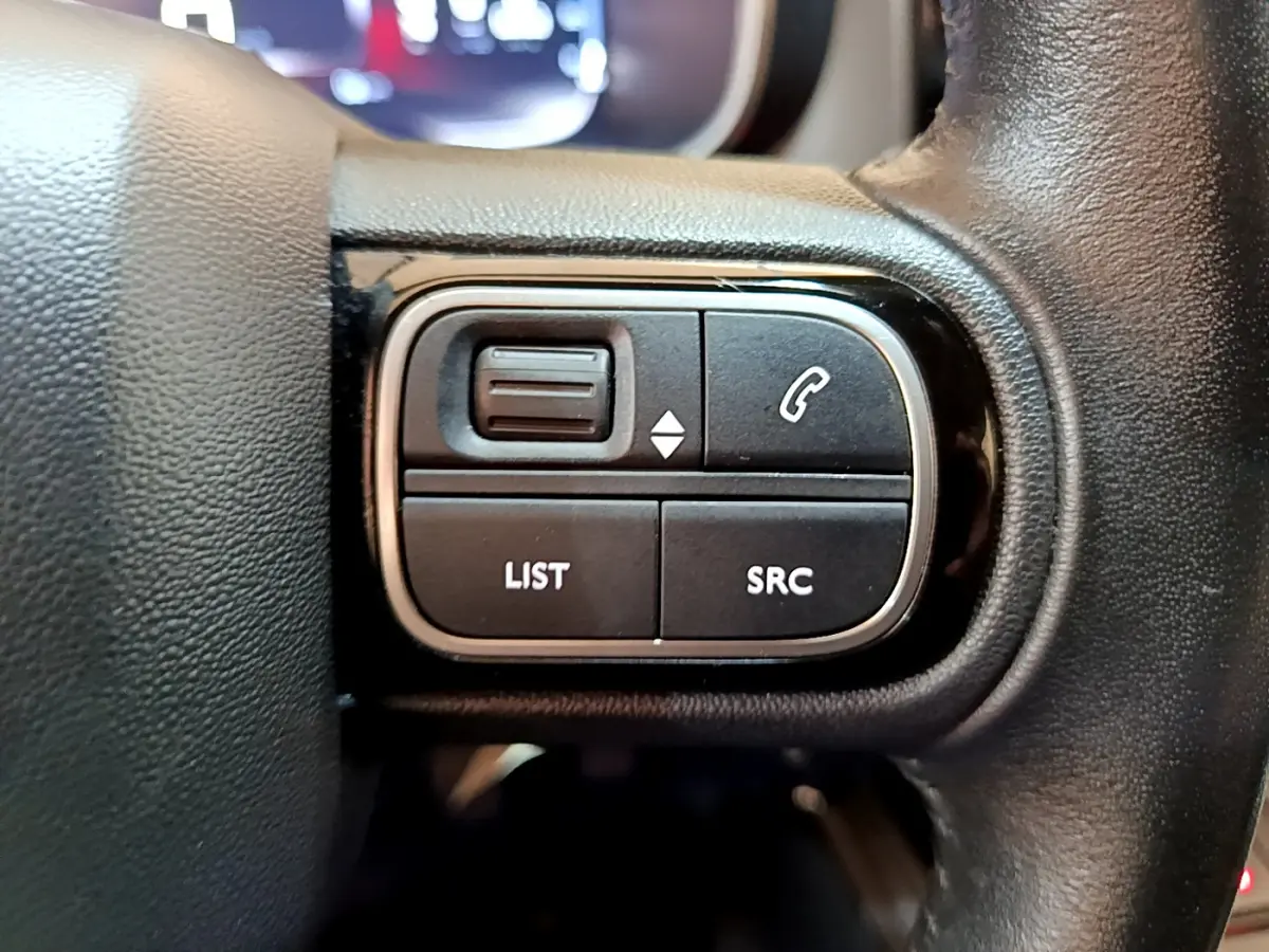 Gros plan sur les commandes audio et téléphone du volant en cuir noir du Citroën C5 Aircross gris foncé 2020.