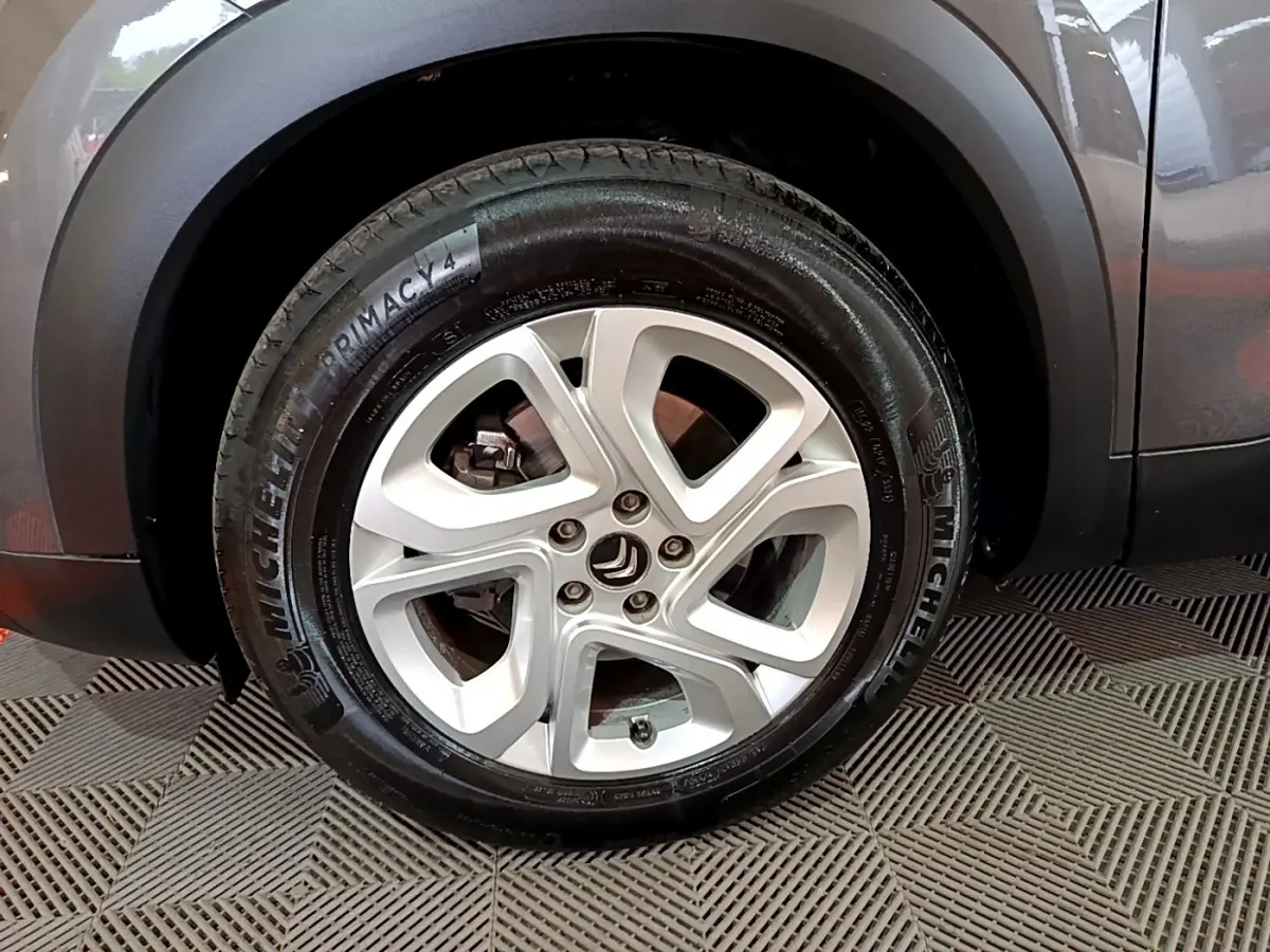 Gros plan sur la roue arrière droite d’un Citroën C5 Aircross gris foncé avec passage de roue noir mat.
