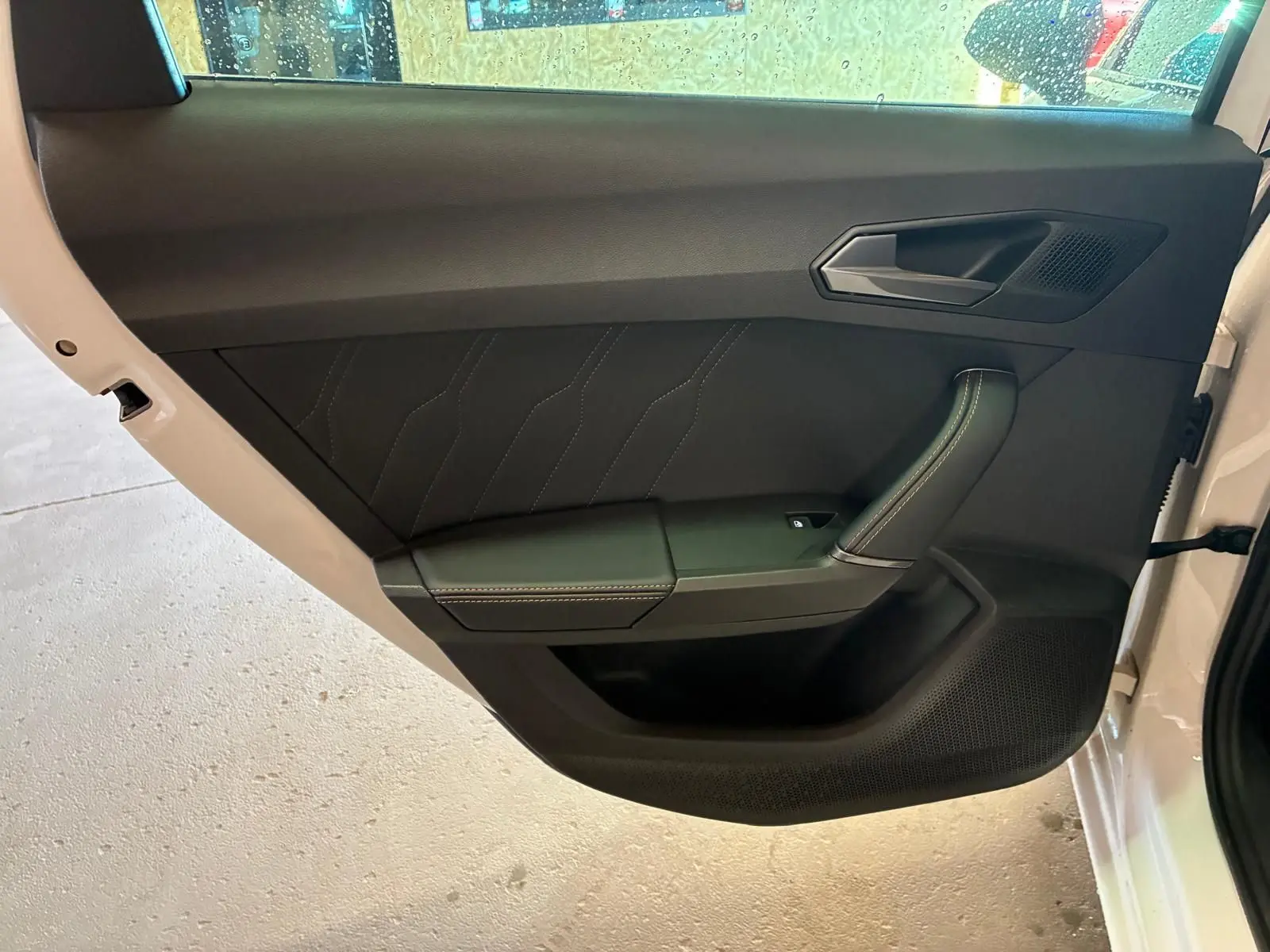 Vue intérieure de la porte arrière droite blanche de la CUPRA LEON ST 2024 avec panneau noir et surpiqûres contrastées.