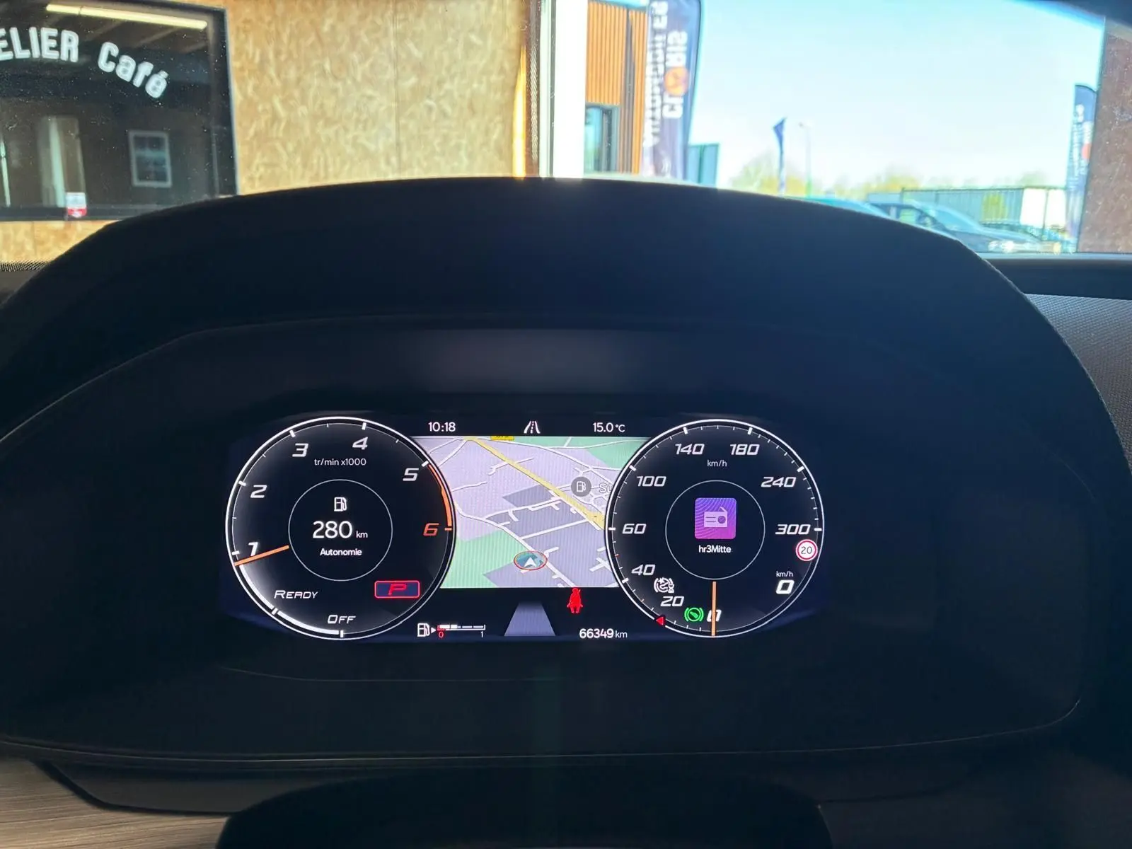 Vue rapprochée du tableau de bord numérique de la CUPRA LEON ST blanc 2024, affichant la navigation et les compteurs.