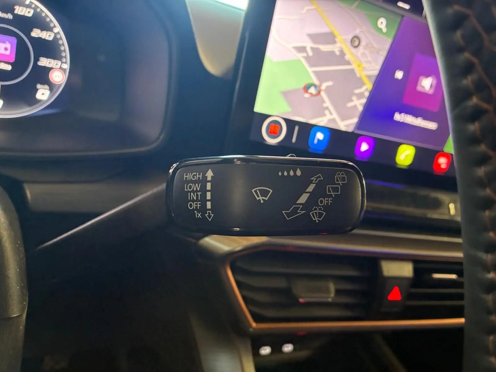 Gros plan sur la commande d’essuie-glace à gauche du volant dans l’habitacle noir du CUPRA LEON ST 2024.