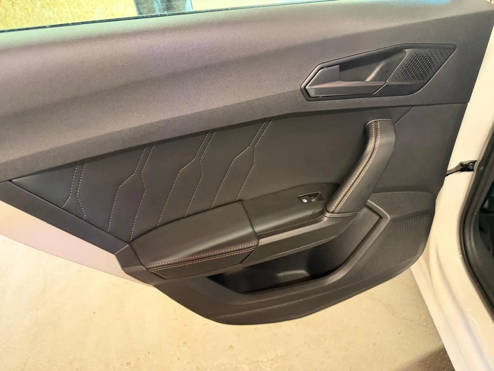Gros plan sur la manette de clignotants à gauche du volant dans l’habitacle noir du CUPRA LEON ST 2024.