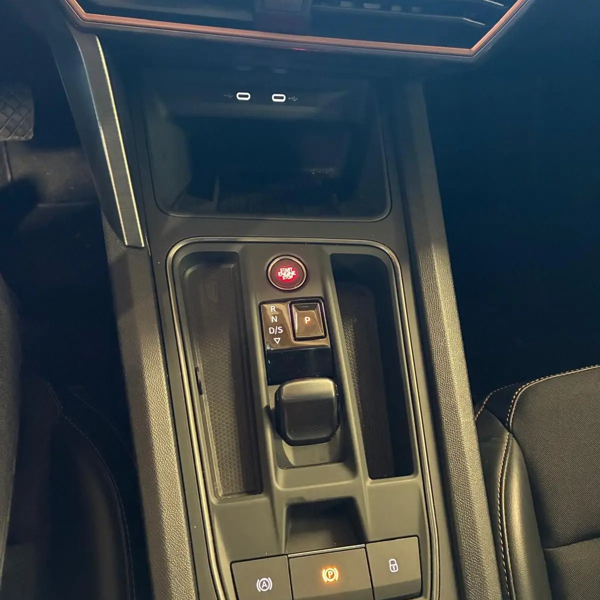 Vue rapprochée de la console centrale noire de la CUPRA LEON ST 2024 avec boutons de démarrage et commande de boîte automatique.