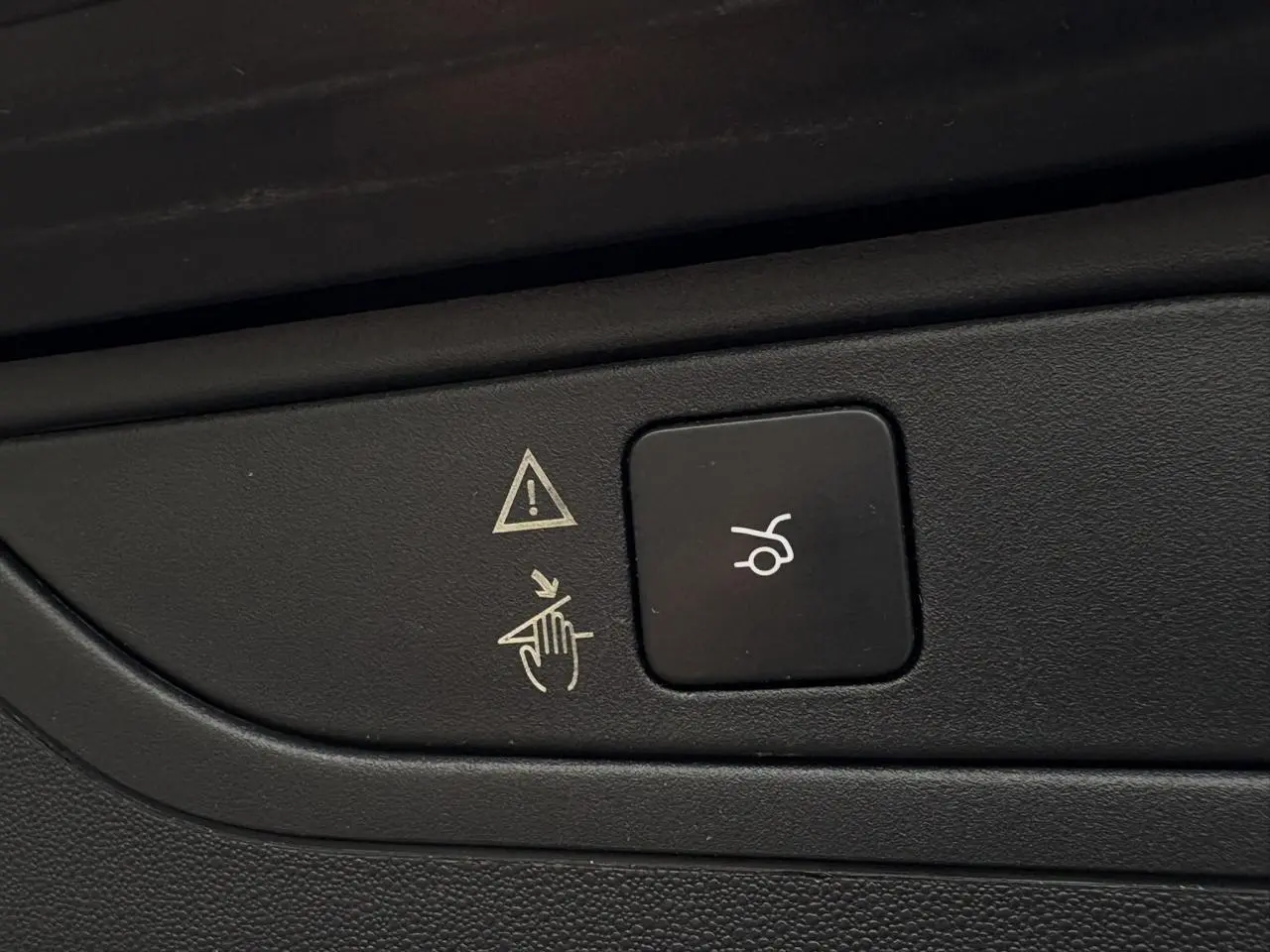 Bouton noir de hayon électrique avec pictogramme blanc, sur panneau intérieur du Citroën C4 Spacetourer gris foncé.