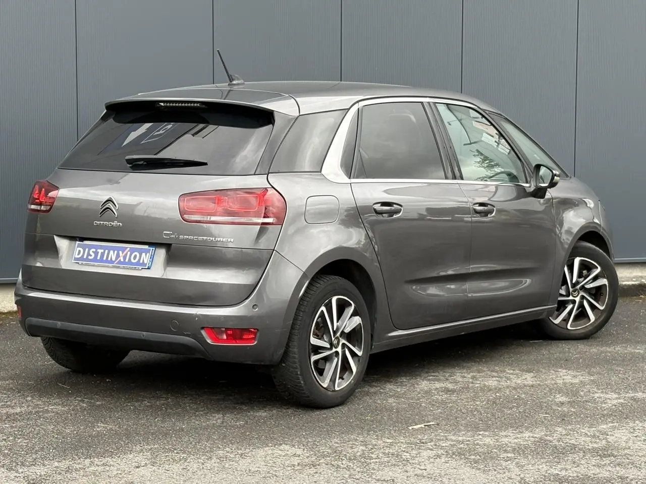 Vue 3/4 arrière droite d'une Citroën C4 Spacetourer gris foncé avec hayon électrique et jantes alliage 17 pouces.