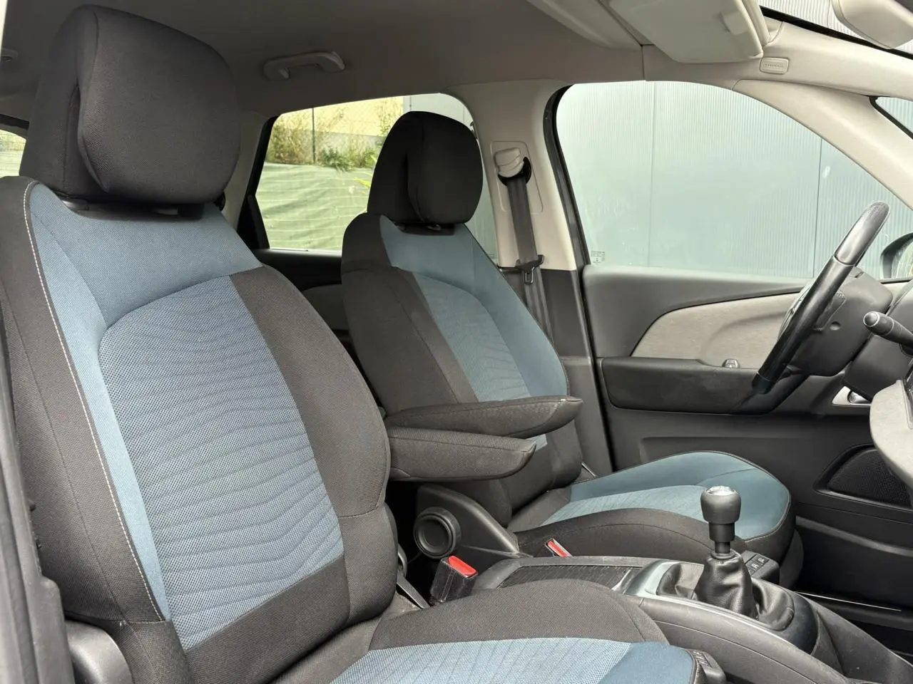 Vue intérieure côté gauche des sièges avant bleu et noir du Citroën C4 Spacetourer 2018 avec levier de vitesses manuel.