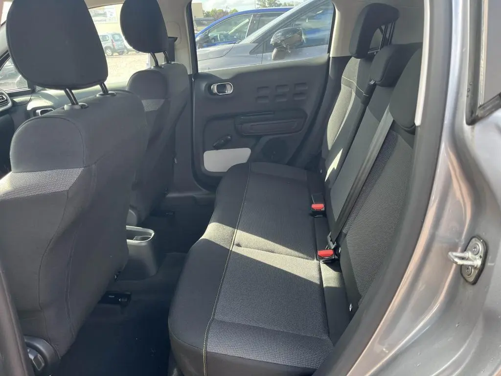 Intérieur arrière de la Citroën C3 gris, vue côté droit montrant les sièges arrière en tissu noir et la portière ouverte.
