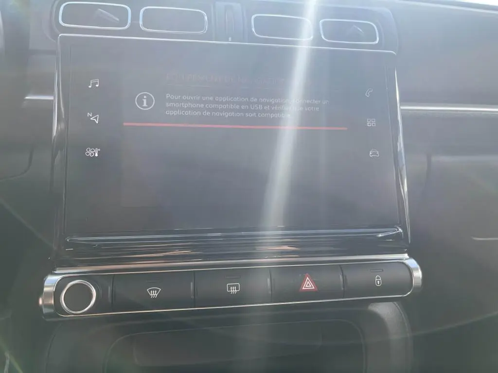 Écran tactile central avec commandes climatisation et boutons de sécurité dans l'habitacle d'une Citroën C3 gris 2022.