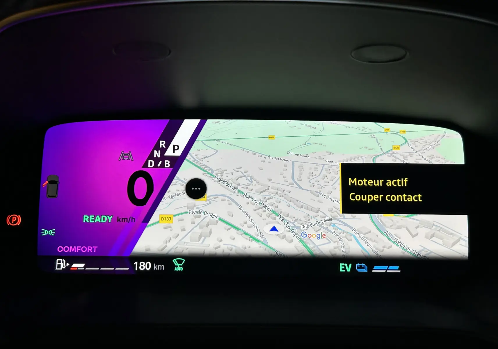 Tableau de bord numérique du Renault Symbioz blanc nacré, affichant la navigation GPS et l'état moteur actif.