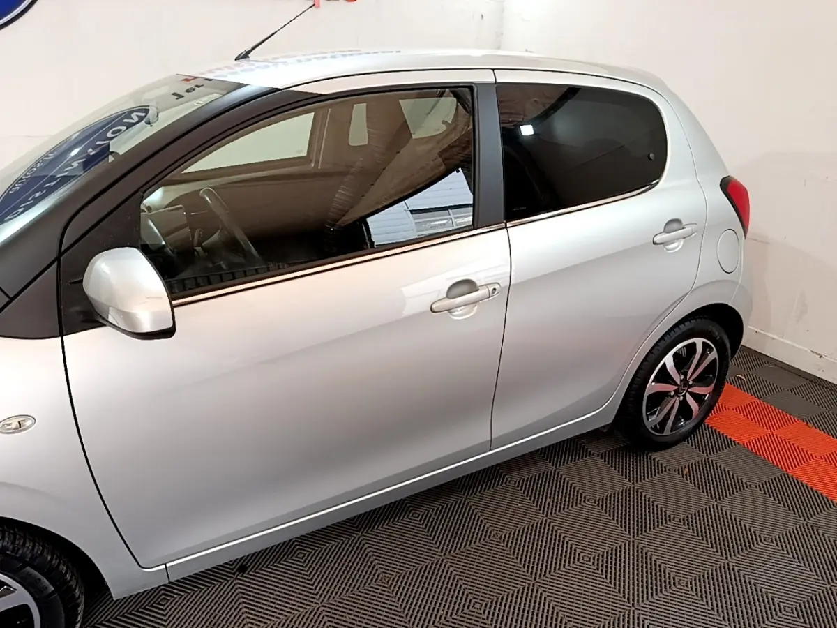 Profil côté gauche d'une Citroën C1 gris clair 2019, avec jantes alliage et vitres arrière teintées.