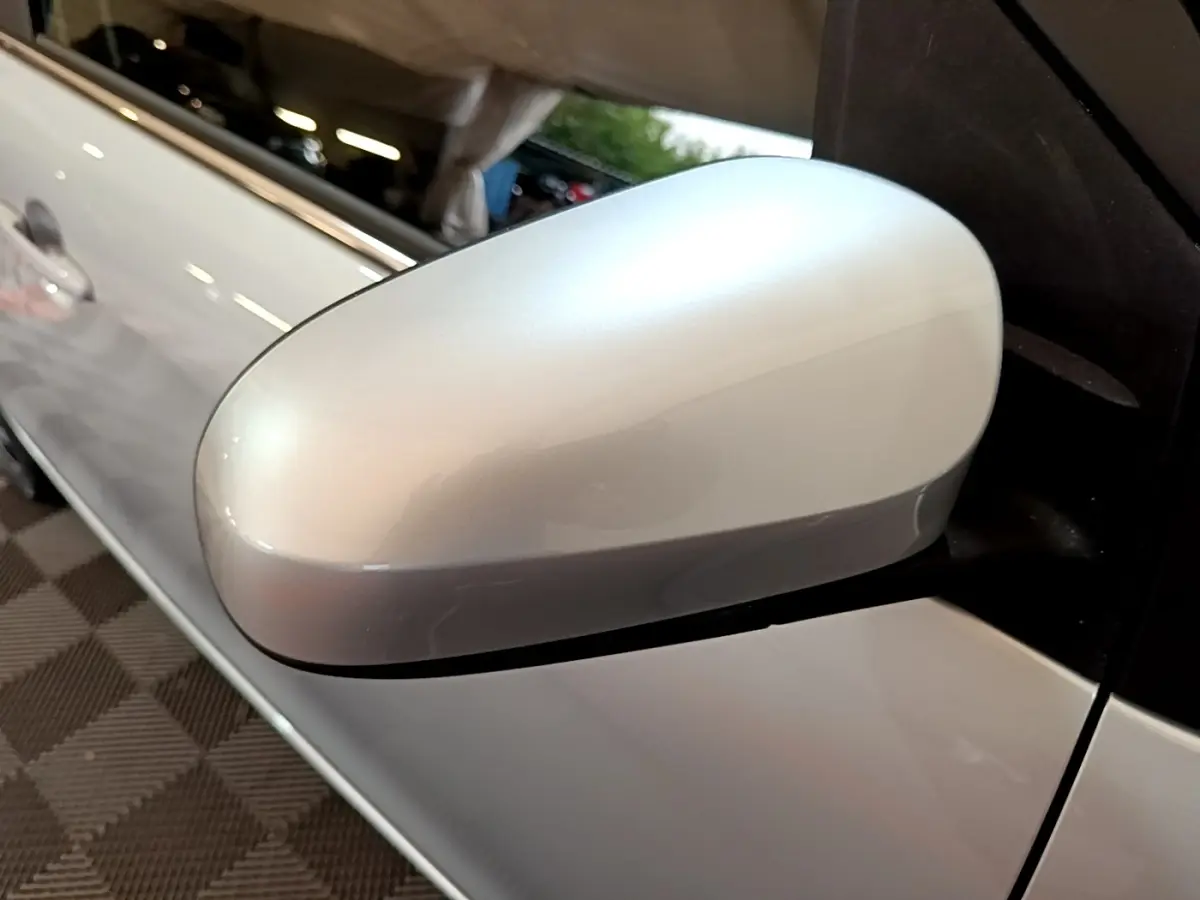 Rétroviseur côté conducteur gris clair de la Citroën C1 VTi 72 Shine, vue rapprochée sur la portière avant.