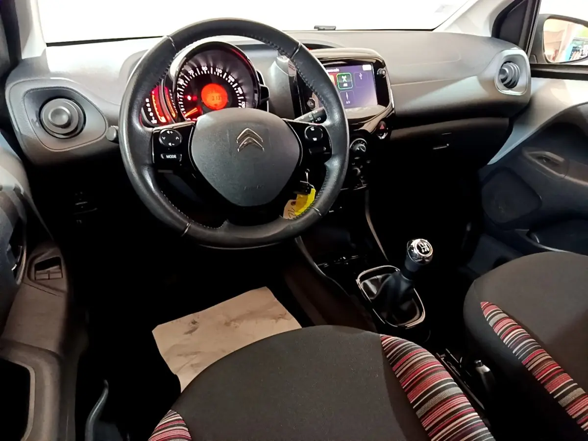 Intérieur de la Citroën C1 2019 vu de face, volant cuir, tableau de bord avec écran tactile 7 pouces et levier de vitesses manuel.