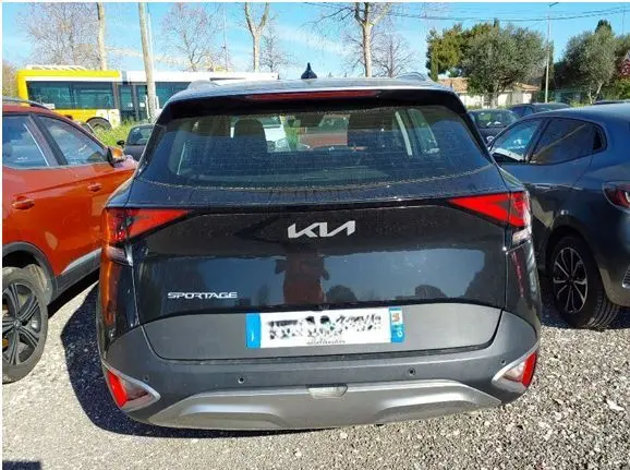 Vue arrière d'un KIA Sportage noir 2022, soulignant les feux arrière en forme triangulaire et le logo moderne au centre.