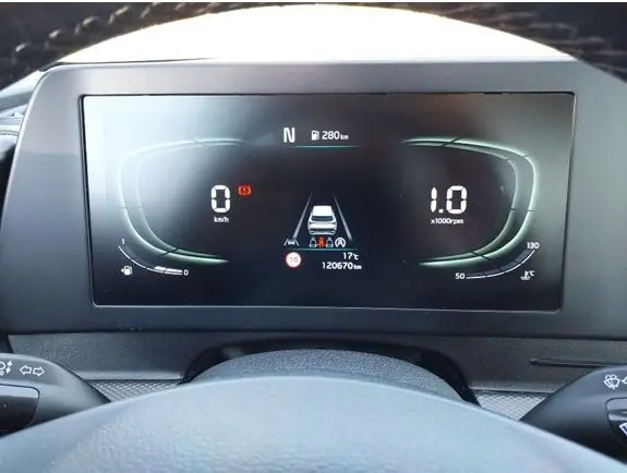 Vue rapprochée du tableau de bord numérique du Kia Sportage noir 2022, affichant la vitesse, le régime moteur et les alertes.