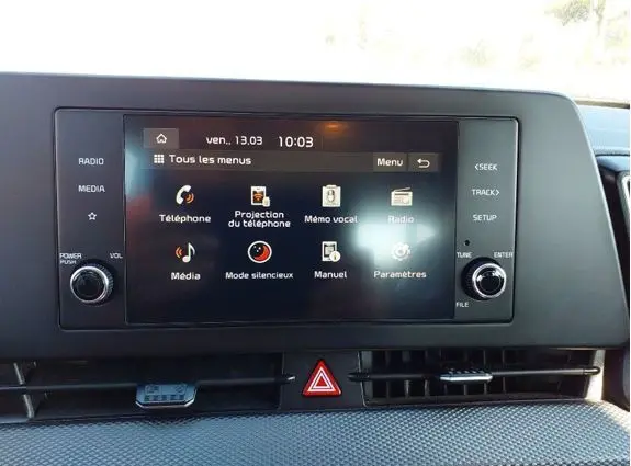 Écran tactile central du Kia Sportage 2022 noir, affichant le menu principal avec options multimédia et téléphone.