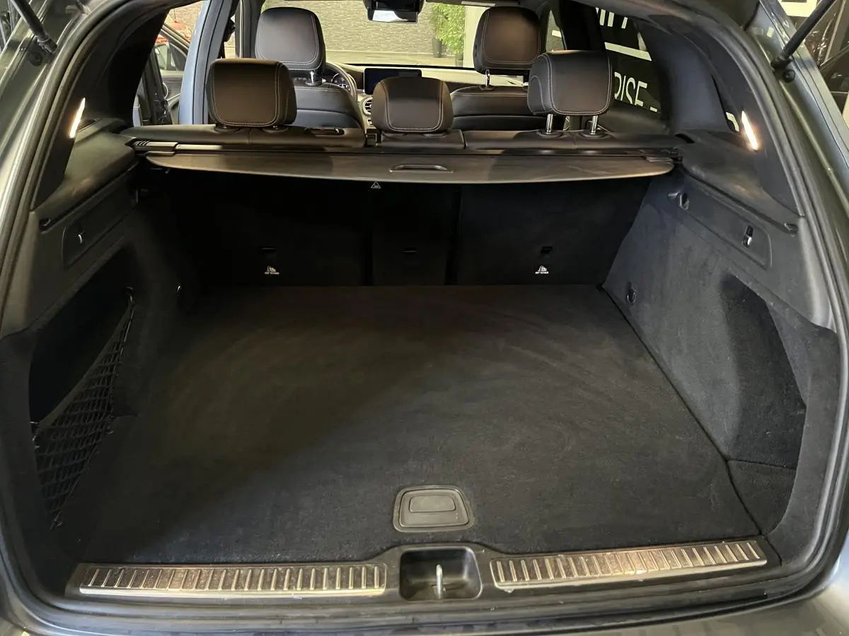 Coffre ouvert d'un Mercedes GLC gris, vue arrière montrant l'espace de chargement et la banquette arrière.