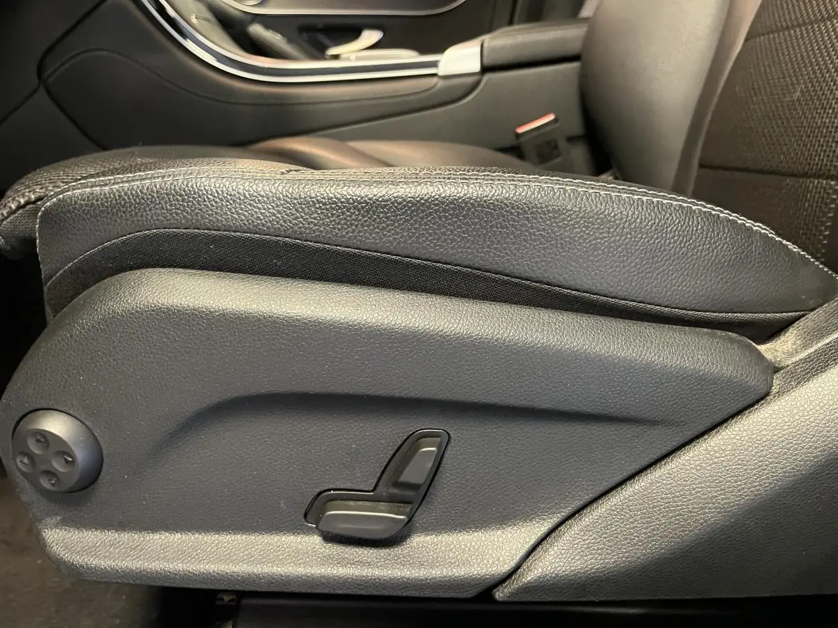Détail du réglage électrique du siège avant droit en cuir noir dans un Mercedes GLC gris de 2019.