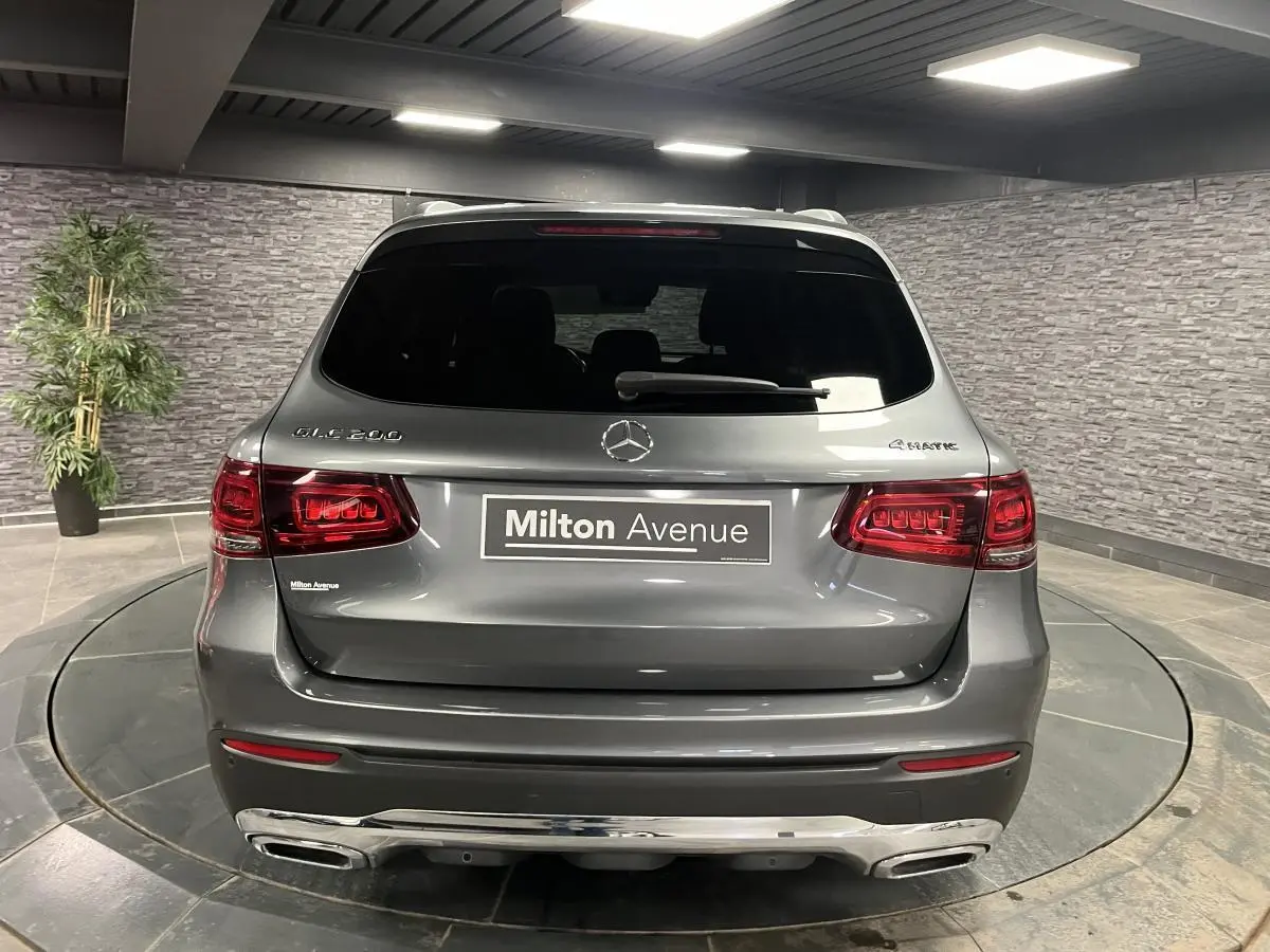 Vue arrière d'un Mercedes GLC 200 4MATIC gris métallisé avec feux LED et double sortie d'échappement chromée.