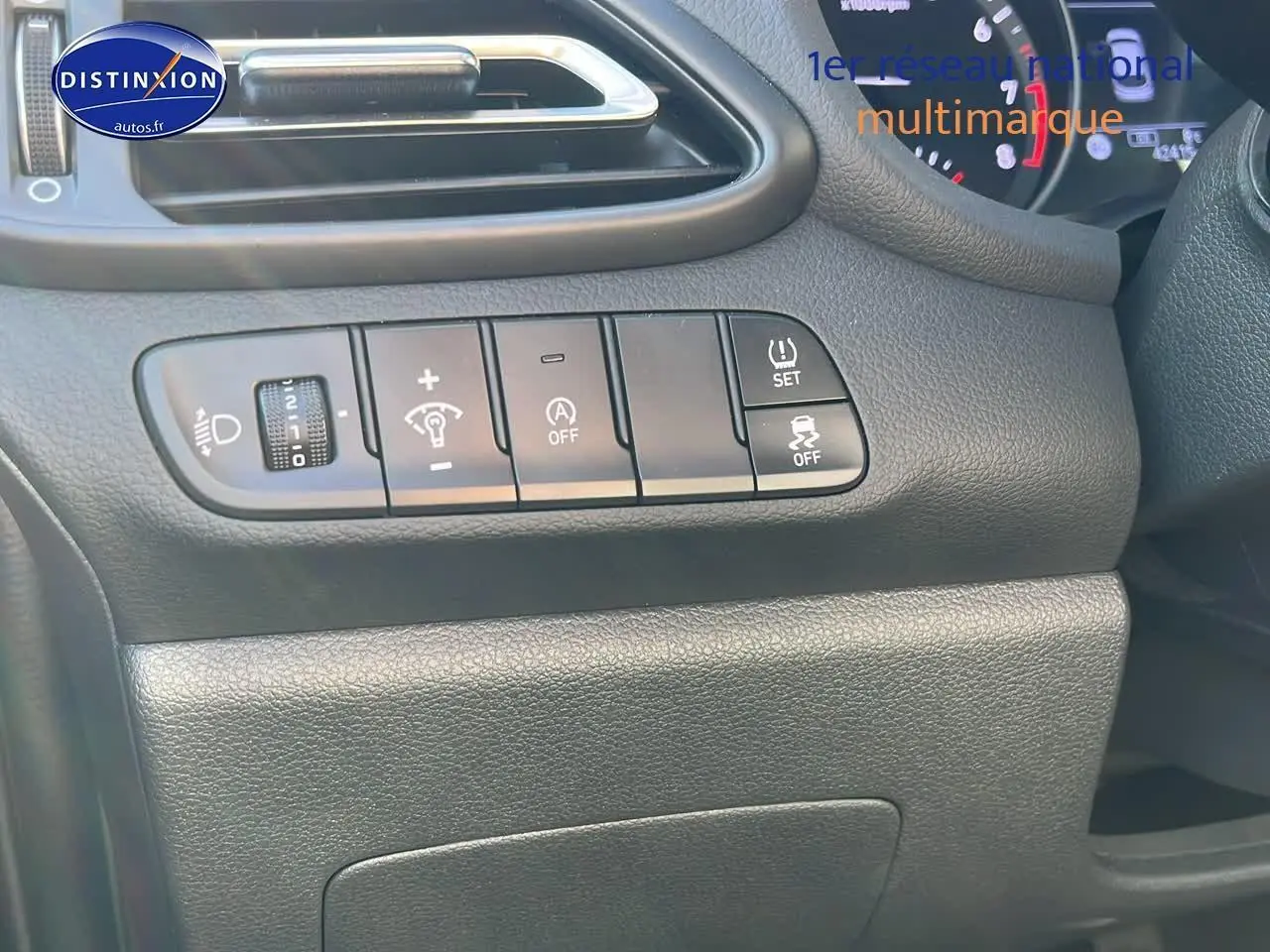 Détail du tableau de bord côté gauche de la Hyundai i30 2024 gris argent avec commandes d'éclairage et assistance.