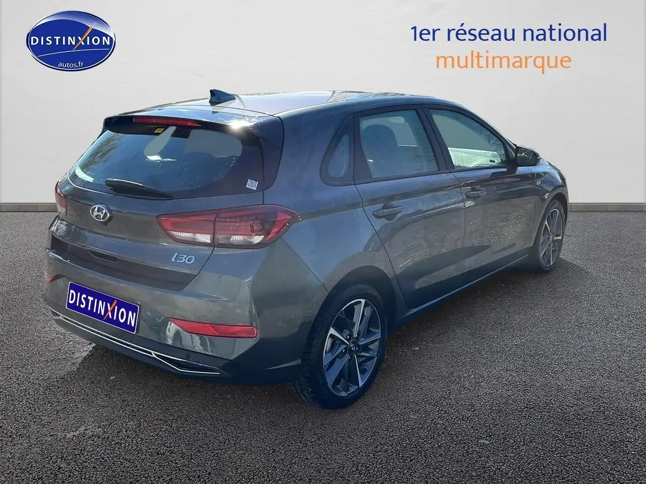 Vue 3/4 arrière droite d'une Hyundai i30 gris argent 2024 avec jantes alliage et feux arrière LED.