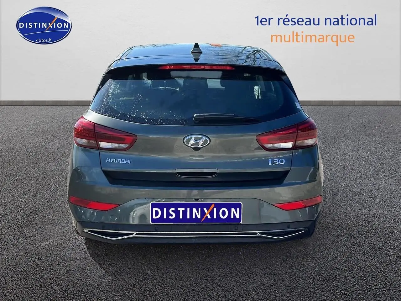 Vue arrière d'une Hyundai i30 gris argent 2024 avec feux LED et logo distinctif sur un fond neutre.