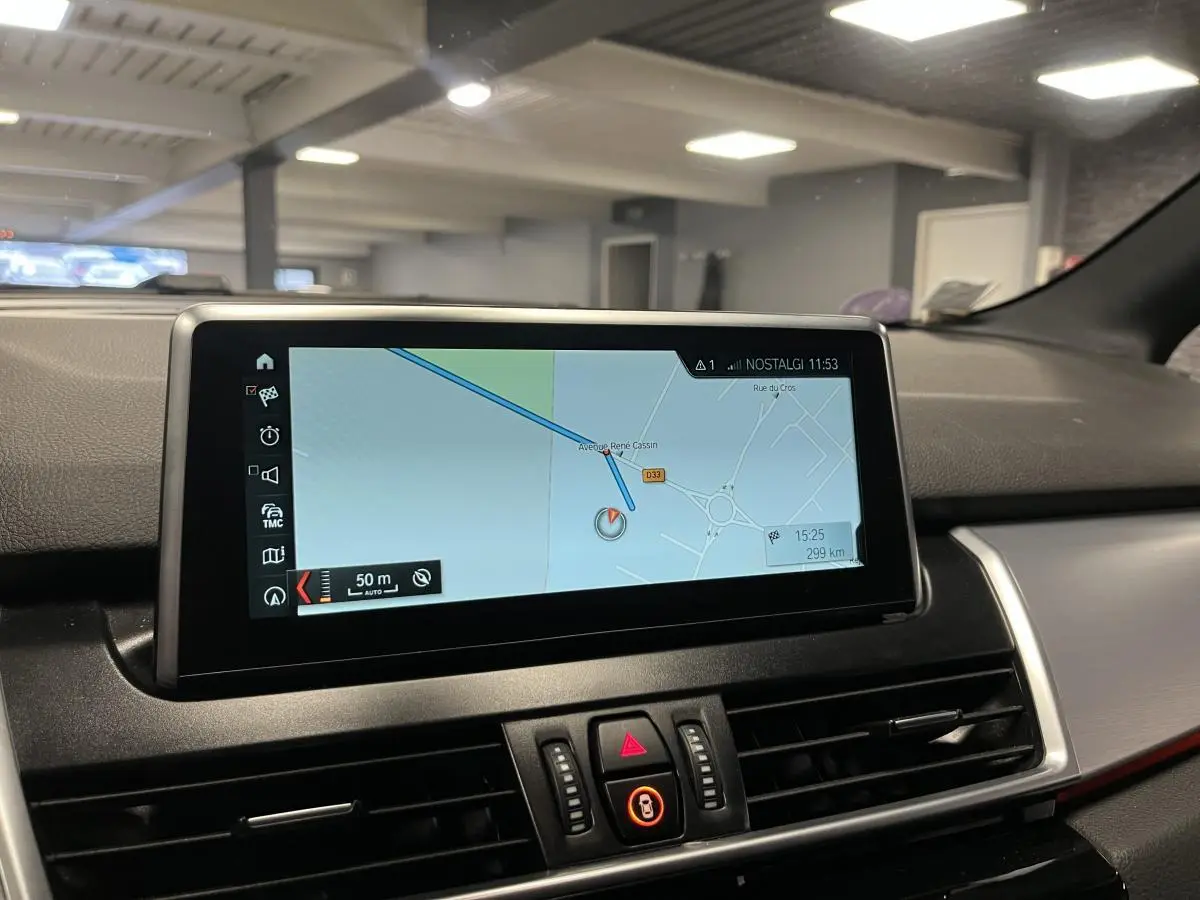 Écran central de navigation affichant une carte, dans l'habitacle gris d'une BMW Série 2 Active Tourer 225xe hybride.