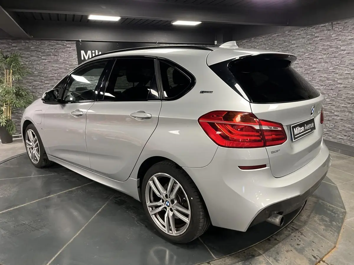 BMW Série 2 225xe Active Tourer gris vue 3/4 arrière droit avec jantes alliage et vitres teintées.