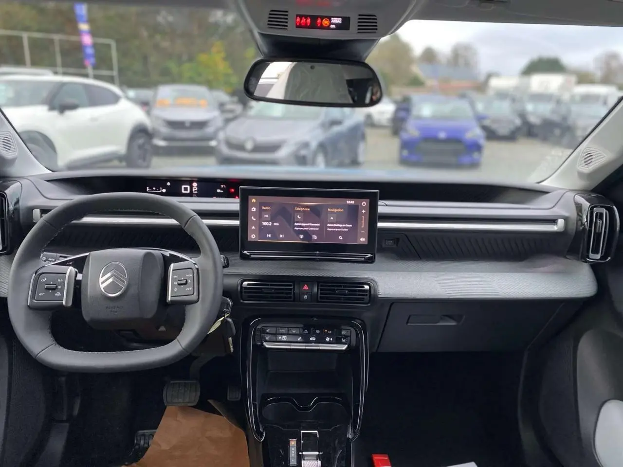 Vue intérieure avant du Citroën C3 Aircross 2025, tableau de bord gris avec écran tactile central et volant multifonctions.