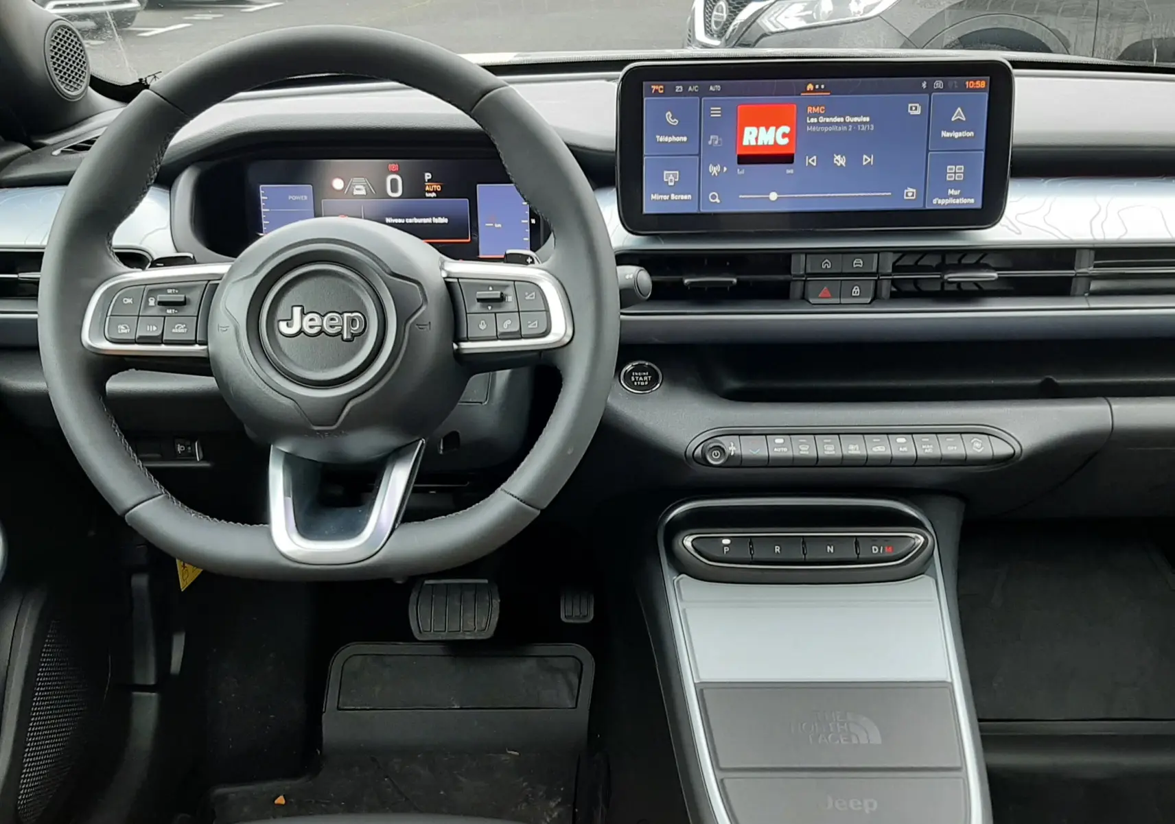 Vue intérieure avant du Jeep Avenger 2025, tableau de bord moderne avec écran tactile et volant multifonction noir.