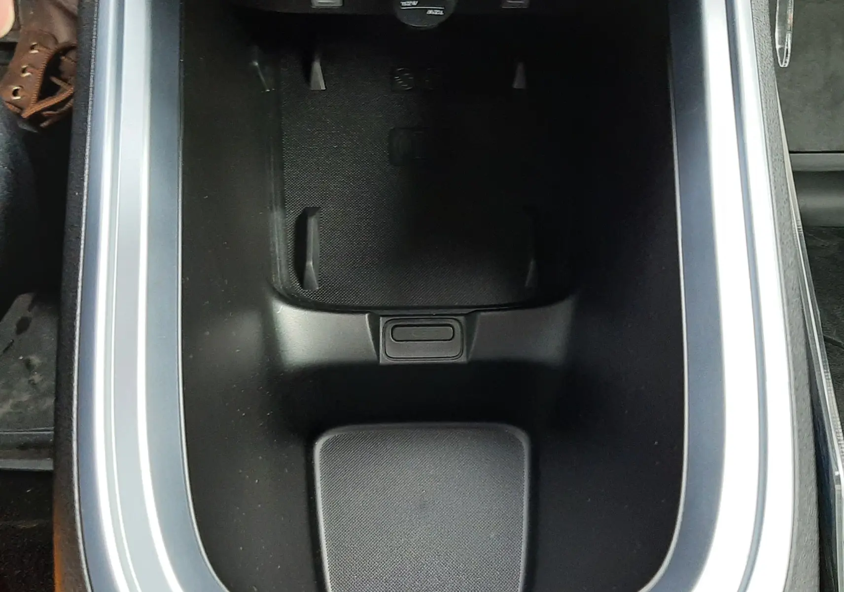 Vue plongeante sur le rangement central noir avec ports USB et prise 12V du Jeep Avenger Storm Grey 2025.