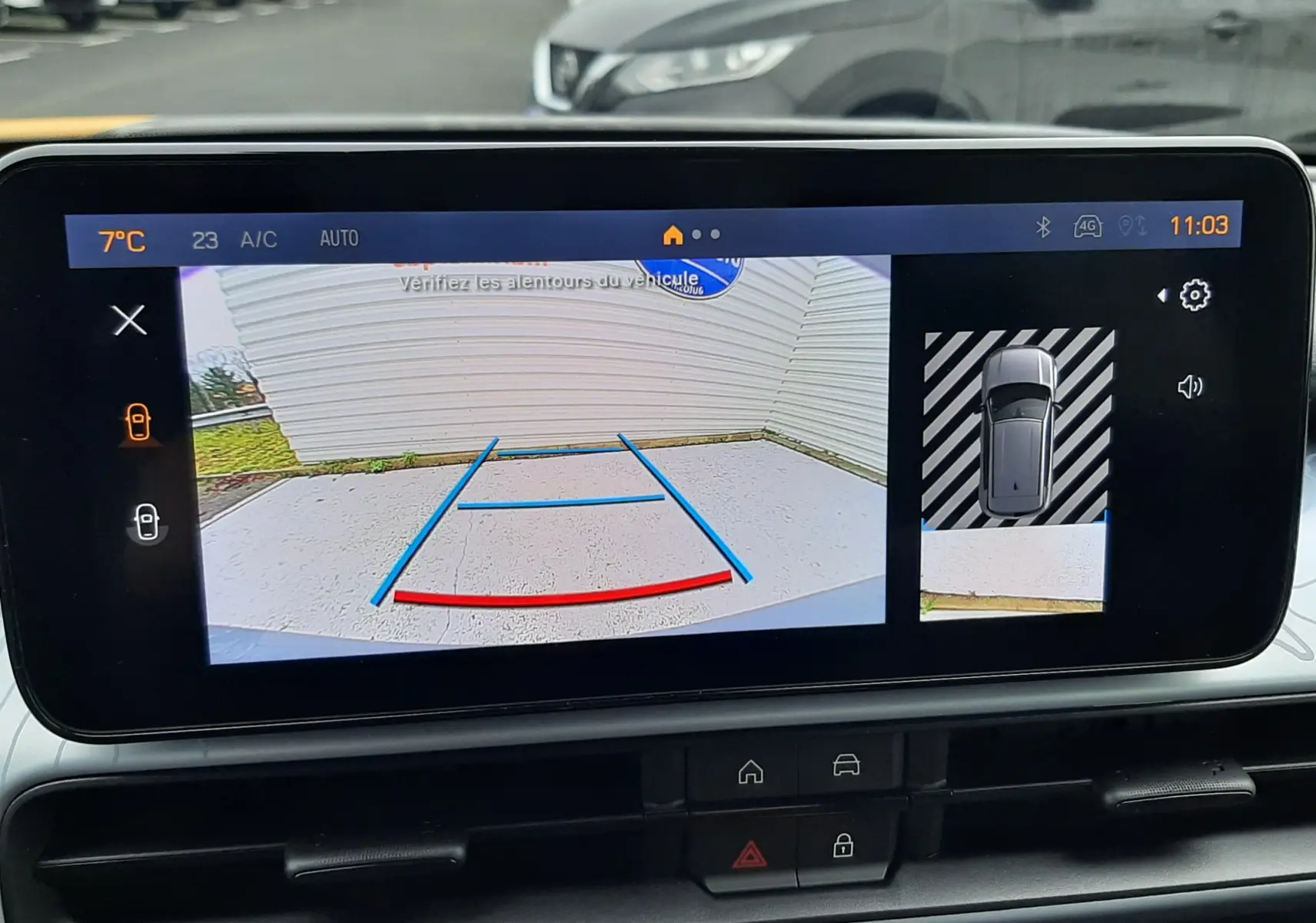 Vue de l'écran intérieur montrant la caméra de recul et l'affichage 360° du Jeep Avenger gris Storm avec toit noir.